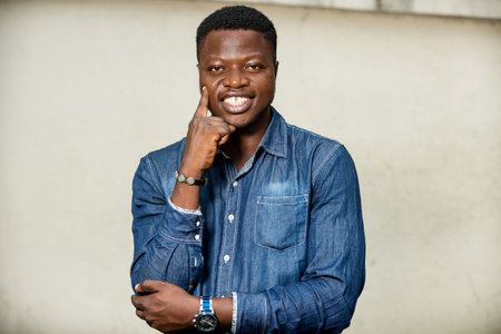 young man standing in shirt looking at camera laughing.
