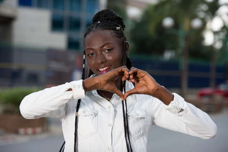 Smiling and happy business woman with heart shaped hands.woman in formal shirt making love gesture. Business or love and romance conceptの写真素材