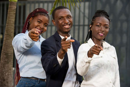 A group of business people giving a hand sign, business women and men standing in the city and united by successの写真素材