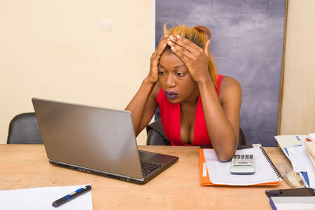 depressed young woman in the office. portrait of beautiful young woman feeling sick, having a headache, office syndrome. health care concept at workplaceの写真素材