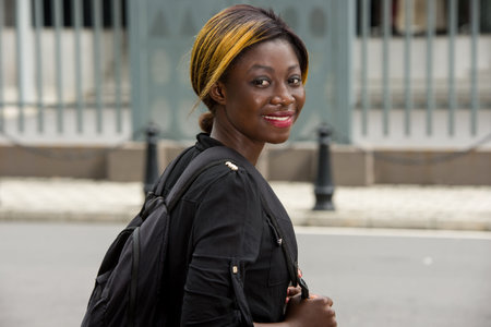 student standing backpack looking at camera smiling.