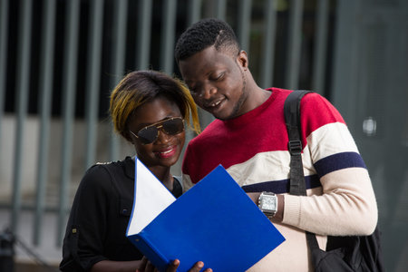 Happy female students with positive expression hold hands, carry backpacks, make friendly speeches,...