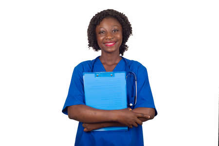 young nurse standing in blue stethoscope blouse on the neck with clipboard looks at camera smiling.の写真素材