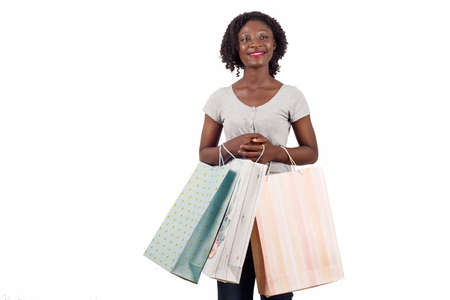 African american woman holding colorful shopping bags, posing on white. Girl with big smile, enjoying shopping purchasesの写真素材