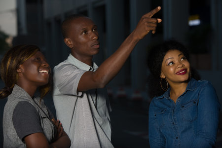 Group of young people walking on the street. three friends having fun and talking outdoors.Young man...