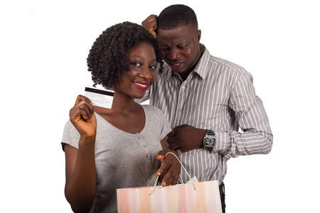 Smiling woman and a man standing and holding shopping bags and a credit card for online shopping or shopping. Man worries about his credit card being exhaustedの写真素材
