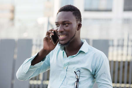 Portrait of modern man and talking on the phone visiting the city street,の写真素材