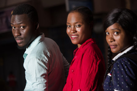group of young people standing outdoors looking at camera smiling.