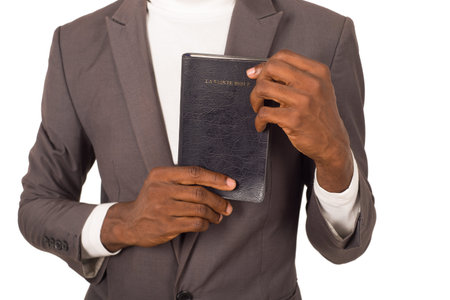 Close-up of person holding a Bible that he presents to the camera.