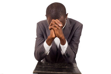 portrait of young pastor kneeling and praying with head down.の写真素材
