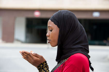 young woman standing outdoors with veil watching her palms.の写真素材