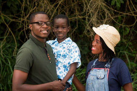 happy family standing near a forest looking at camera smiling.の写真素材