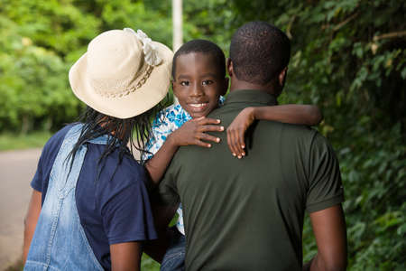 a family standing in a park and giving back to the camera.の写真素材