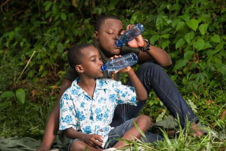 a family in the countryside with a bottle of water.の写真素材