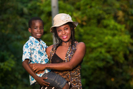 young mother with child having fun at the park.Good loving family.Young happy mother holding her son in arms.の写真素材