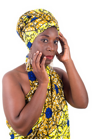 young african woman standing in loincloth in a studio hand on cheek and looking at camera in profile.の写真素材