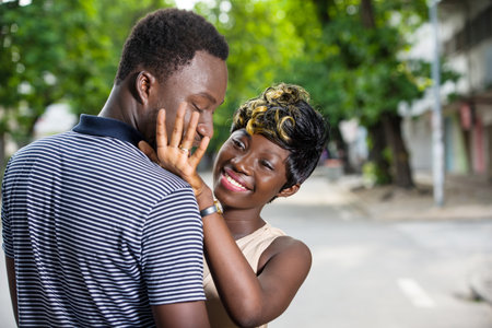 young woman standing outdoors admiring engagement ring while smiling.の写真素材