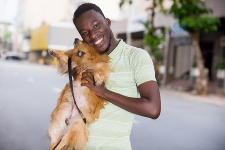 Man holding his dog tenderly. Man with his dog playing in the park. The owner hugs his pet.の写真素材