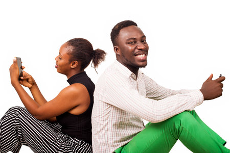 young people or happy couple sitting back handling both a laptop isolated on white background.concept communication and human relationship or loveの写真素材