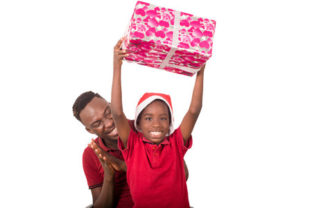 Funny smiling family, father and son with christmas hat on their head hold a present in hand.の写真素材