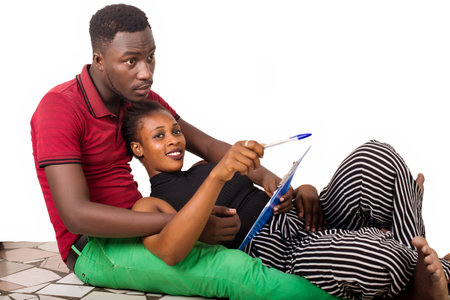 young woman lying on the thighs of her boyfriend showing him something smiling.の写真素材