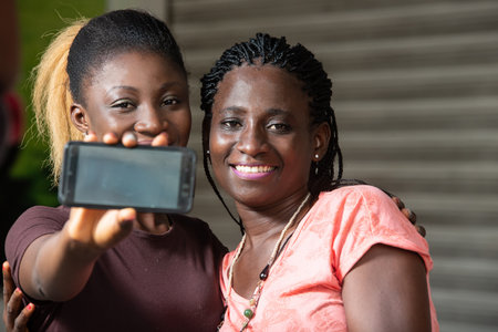 sitting girls showing the mobile phone screen smiling.の写真素材