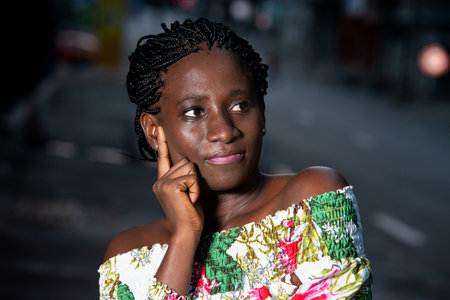 young african woman standing outside looking at the camera.の写真素材