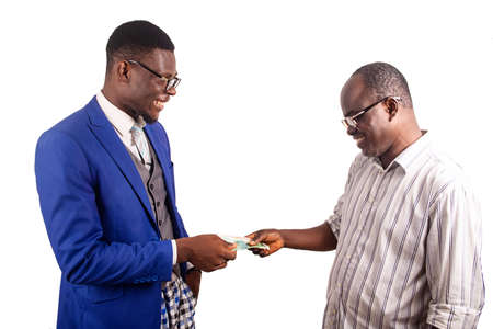a businessman in jacket standing on white background receiving bank notes from the hands of his colleague smilingの写真素材