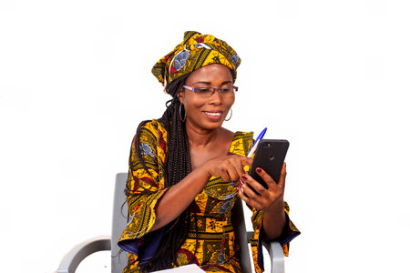 Portrait of happy adult businesswoman sitting pointing on smartphone screen outdoors writing in her...