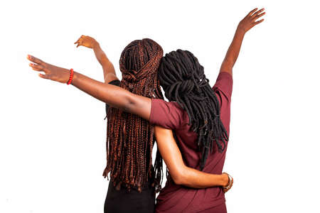 two beautiful girls with long braids standing backの写真素材