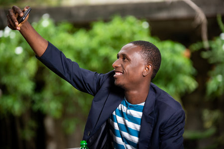 happy young black african american businessman smiling and taking selfie photo self portrait with...