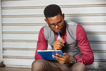 Serious young businessman sitting and thoughtful in formal connection examining and reflecting on...