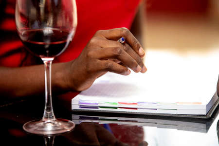 a female hand holding a pen inside a refreshment bar.の写真素材