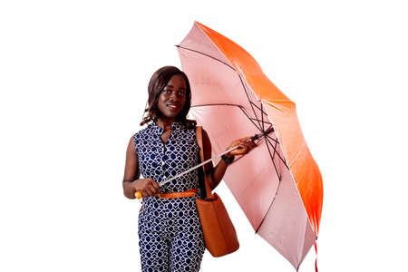 beautiful young businesswoman standing under an umbrella looking at the camera smiling. isolated on white backgroundの写真素材