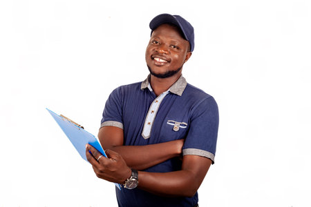 young delivery man standing in blue uniform standing and holding a paper clip with document smiling