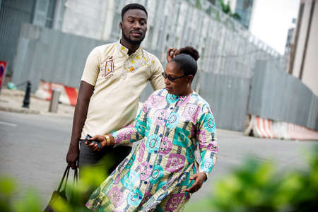 happy beautiful mature couple talking while walking outdoors on the street while smilingの写真素材