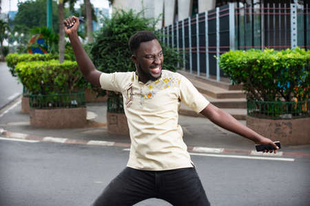 handsome young man very happy and excited doing winner's gesture with arms raised, smiling and screaming for successの写真素材