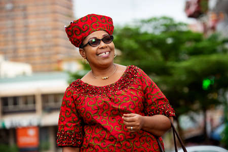 beautiful mature business woman in red clothes standing and going to workの写真素材