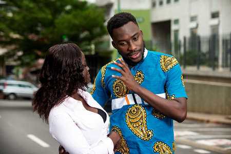 beautiful couple in love standing outdoors talking to each other while smiling.の写真素材