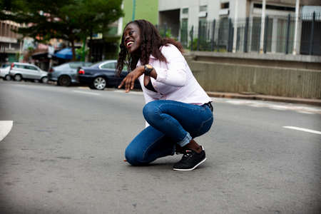 beautiful young african woman smiling outdoors in the streetの写真素材