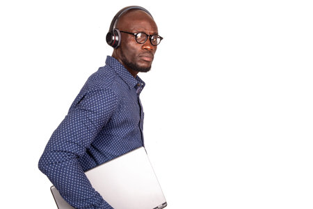 handsome businessman standing on white background with headset looking at camera while holding...