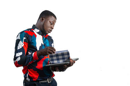 handsome serious young businessman holding and turning pages of his notebookの写真素材