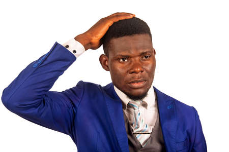 an attractive young businessman standing isolated on white background thinking by touching his headの写真素材