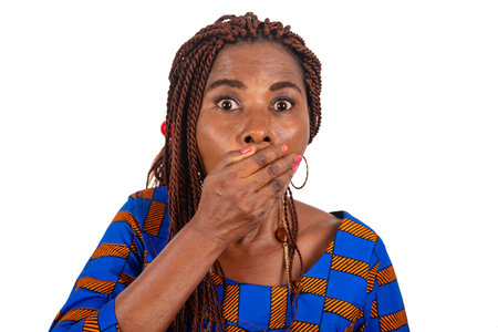 shocked adult business woman has widely opened her eyes and covers her mouth with the hand