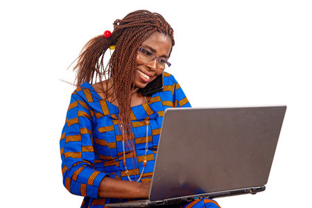 beautiful businesswoman in traditional dress sitting on white background working with laptop and...