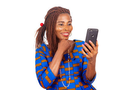 beautiful adult businesswoman making a video call using mobile phone with hand hand on chin while smilingの写真素材