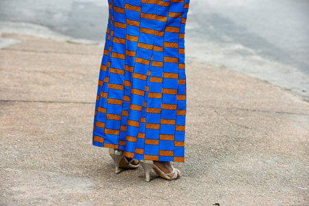 woman walking in the street with high beige heels.