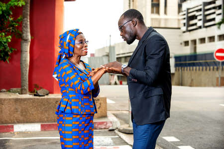 serious businessman and businesswoman discussing business standing on the street smiling.の写真素材