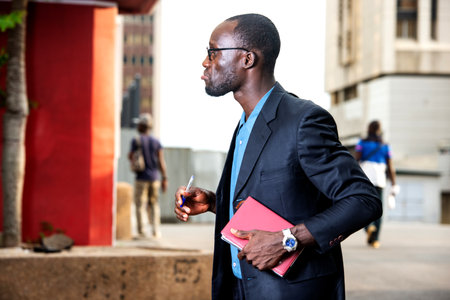 serious adult businessman holding a notebook and looking asideの写真素材