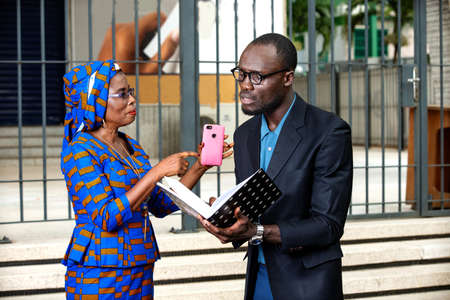 Business people holding a notebook and having discussion outdoor.の写真素材